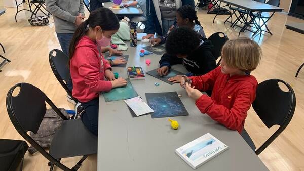 Students at a youth astronomy program draw their own galaxies. 